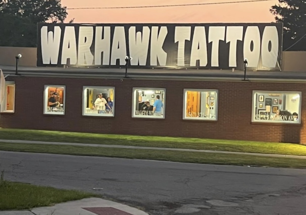 The lit WarHawk Tattoo sign above the shop on N Jameson Ave in Lima, Ohio at dusk